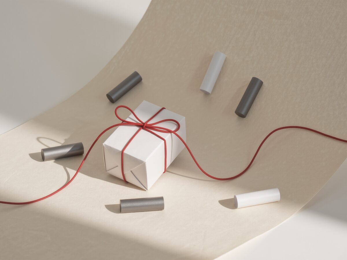 A small white parcel box tied with a red cable.