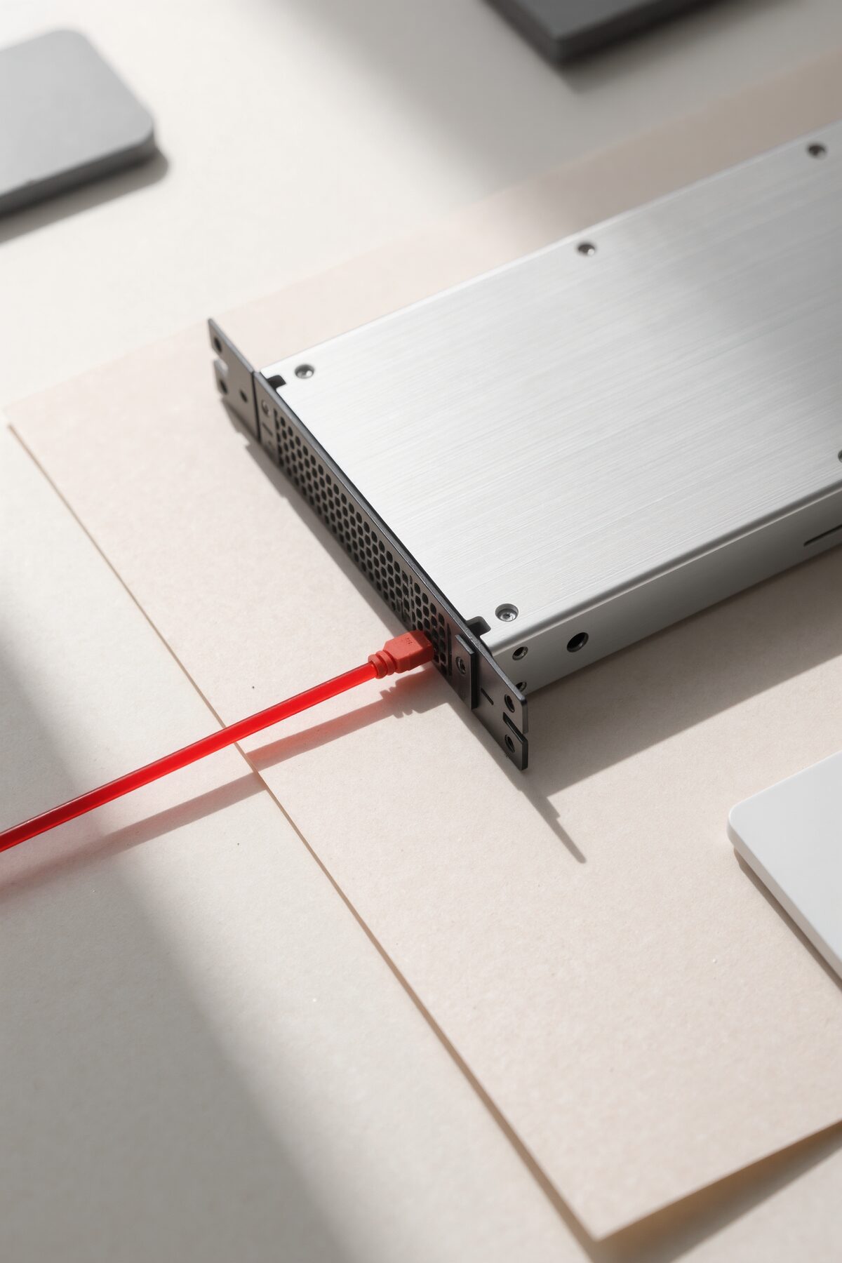 An aluminium server blade with a red patch cable plugged in.